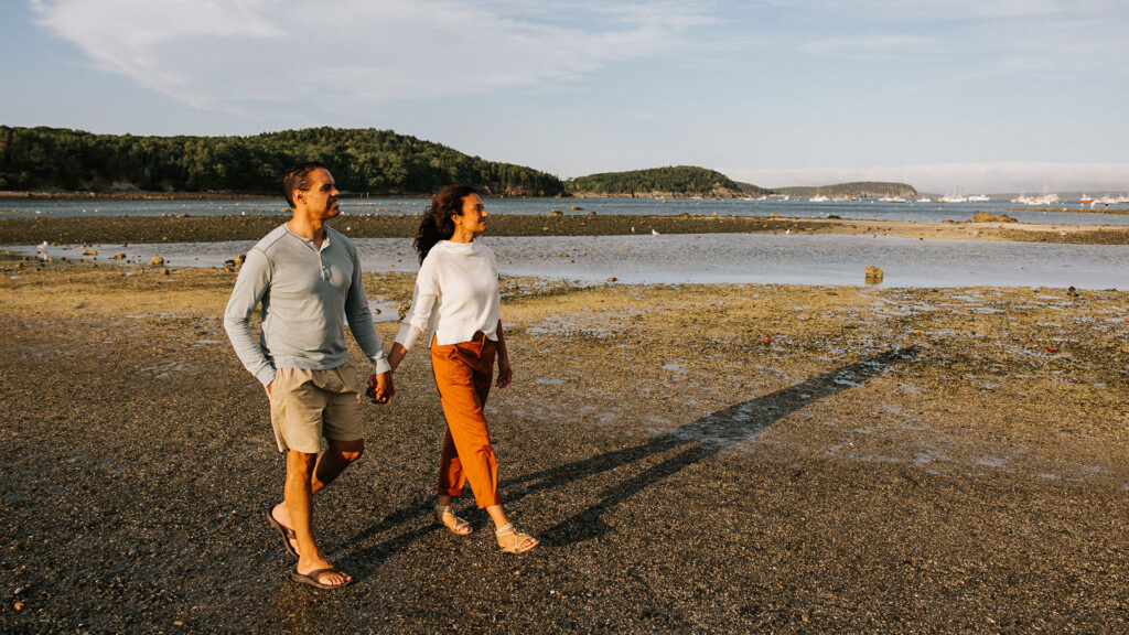 A couple strolls to Bar Island during low tide in Bar Harbor.