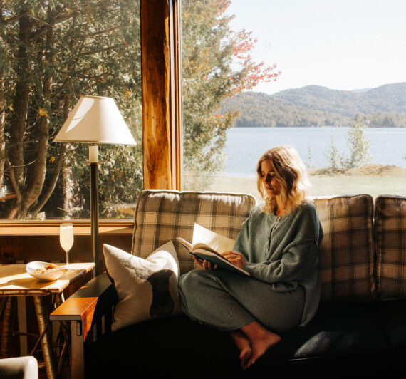 Reading in a lakefront cabin at Lake Placid Lodge