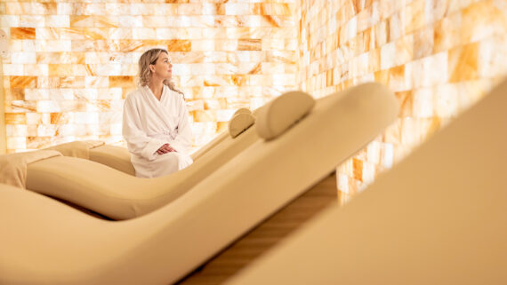 A woman sits in the Salt & Sound Lounge at an Opal Spa.